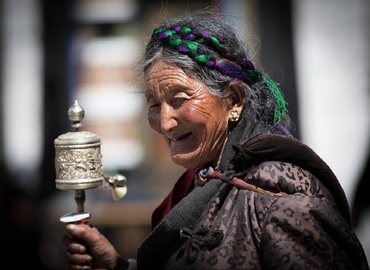 A Tibet granny with a prayer wheel.