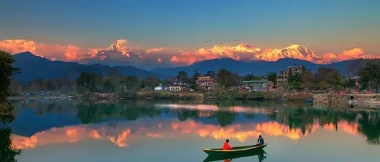 Phewa Lake is surrounded by snow-capped Annapurna Mountains.