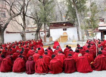 A lama is preaching to a group of monks.