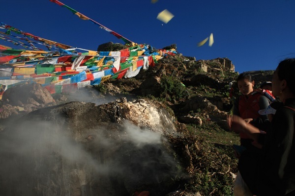 People hang the prayer flags on the high hills of Wangbur Mountain