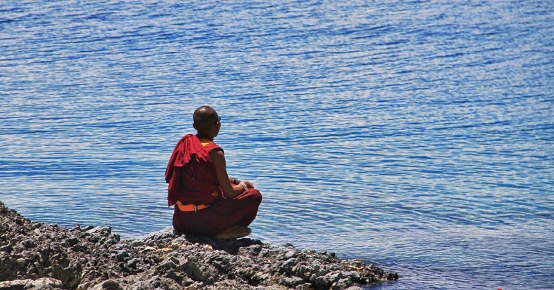 A monk is meditating at Namtso lakeside