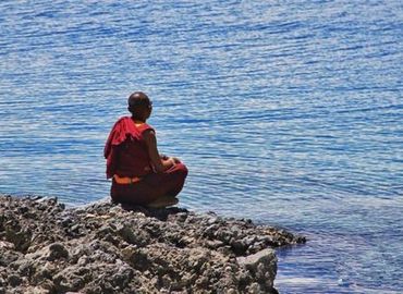A monk is meditating at Namtso lakeside.