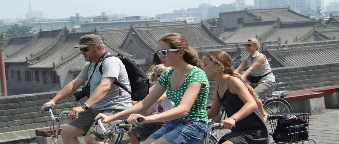 Family members are cycling on the ancient city wall.
